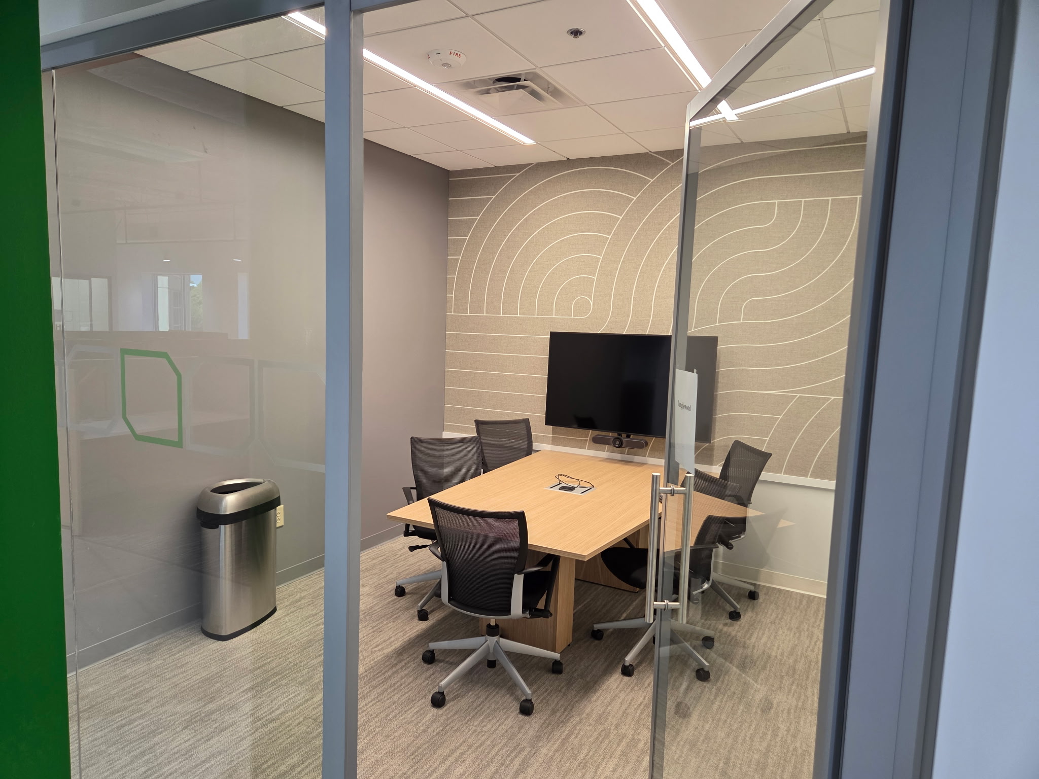 Compact meeting table and chairs inside a glass enclosed room