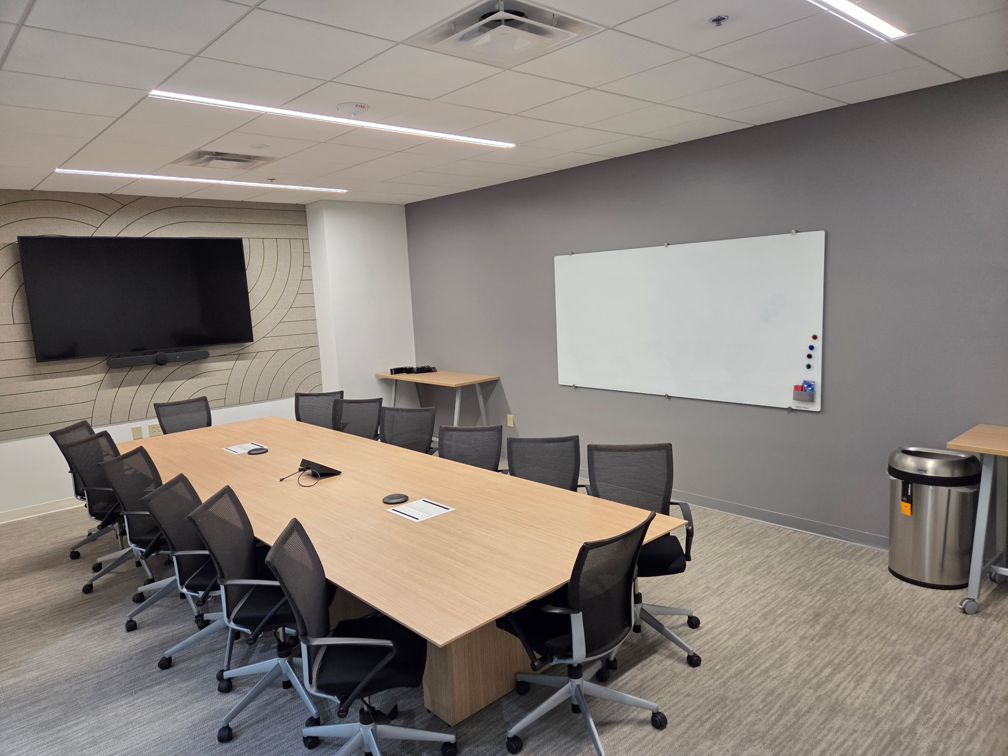 Wood conference table surrounded by black meeting chairs