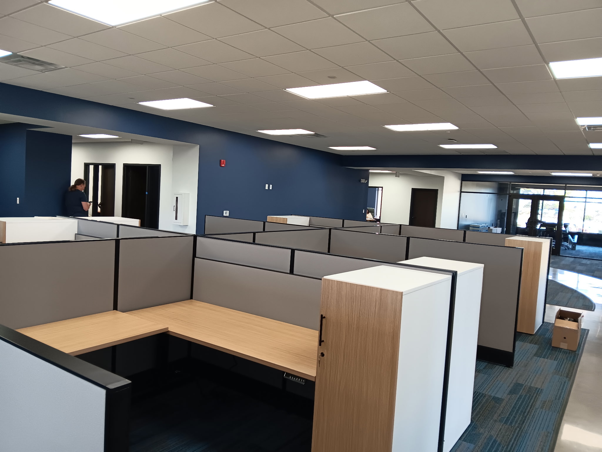 Low panel office cubicles with wood desktops and storage