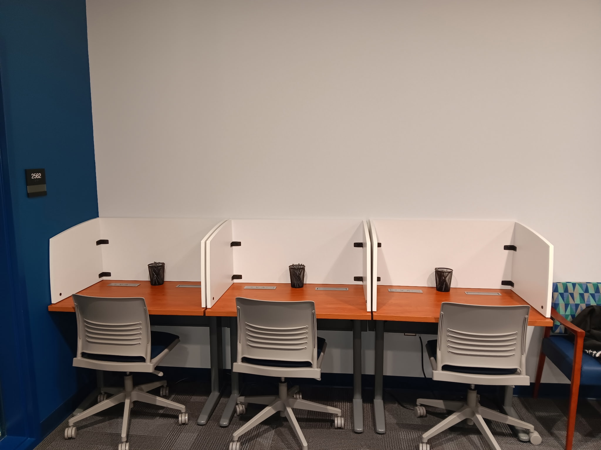 Individual desks with privacy screens and office chairs