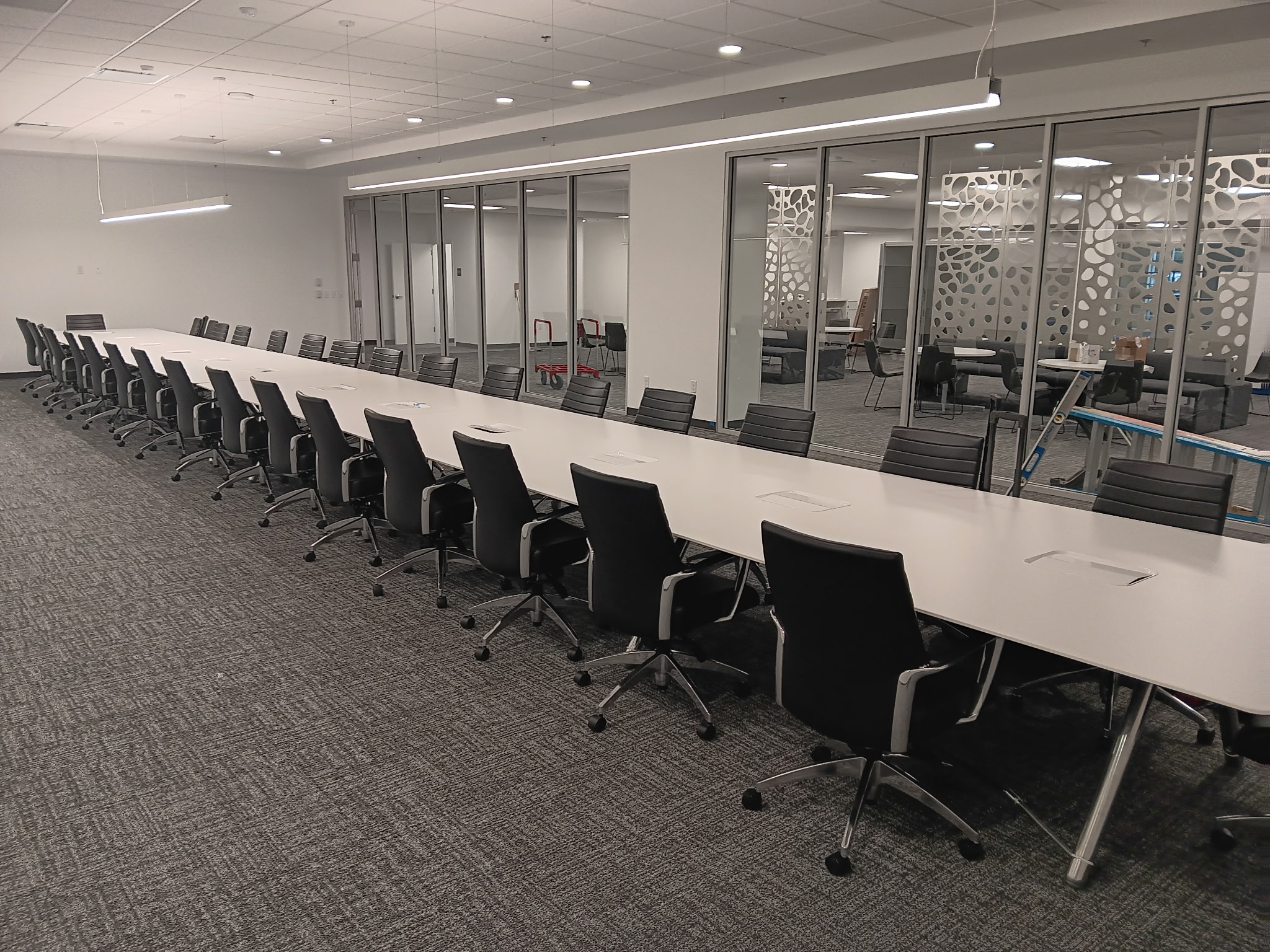 Long conference table with rows of black chairs